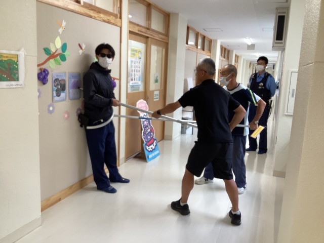 取り押さえている職員