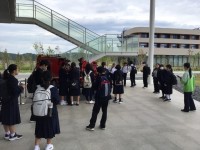 伝承館に展示されている消防自動車の前で説明を聞く1年生